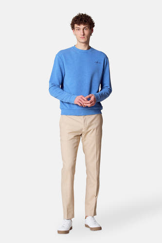 Blauwe sweater met ronde hals van Le Fabuleux Marcel de Bruxelles, gedragen met beige pantalon en witte sneakers.
