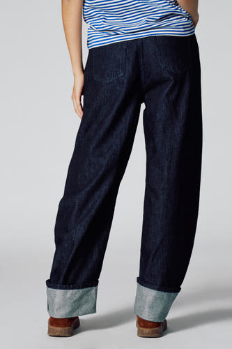 Donkerblauwe denim LE JEAN BALLOON jeans van Le Fabuleux Marcel de Bruxelles, met omgeslagen pijpen en een gestreepte top.

