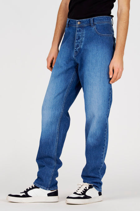 Jean droit bleu de Le Fabuleux Marcel de Bruxelles, avec fermeture à boutons et aspect usé.