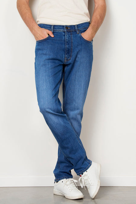 Jean slim en denim bleu moyen de Le Fabuleux Marcel de Bruxelles, avec des baskets blanches et un t-shirt blanc.