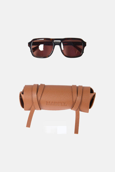 Bruine zonnebril van Le Fabuleux Marcel de Bruxelles, met een bijpassende bruine lederen etui.
