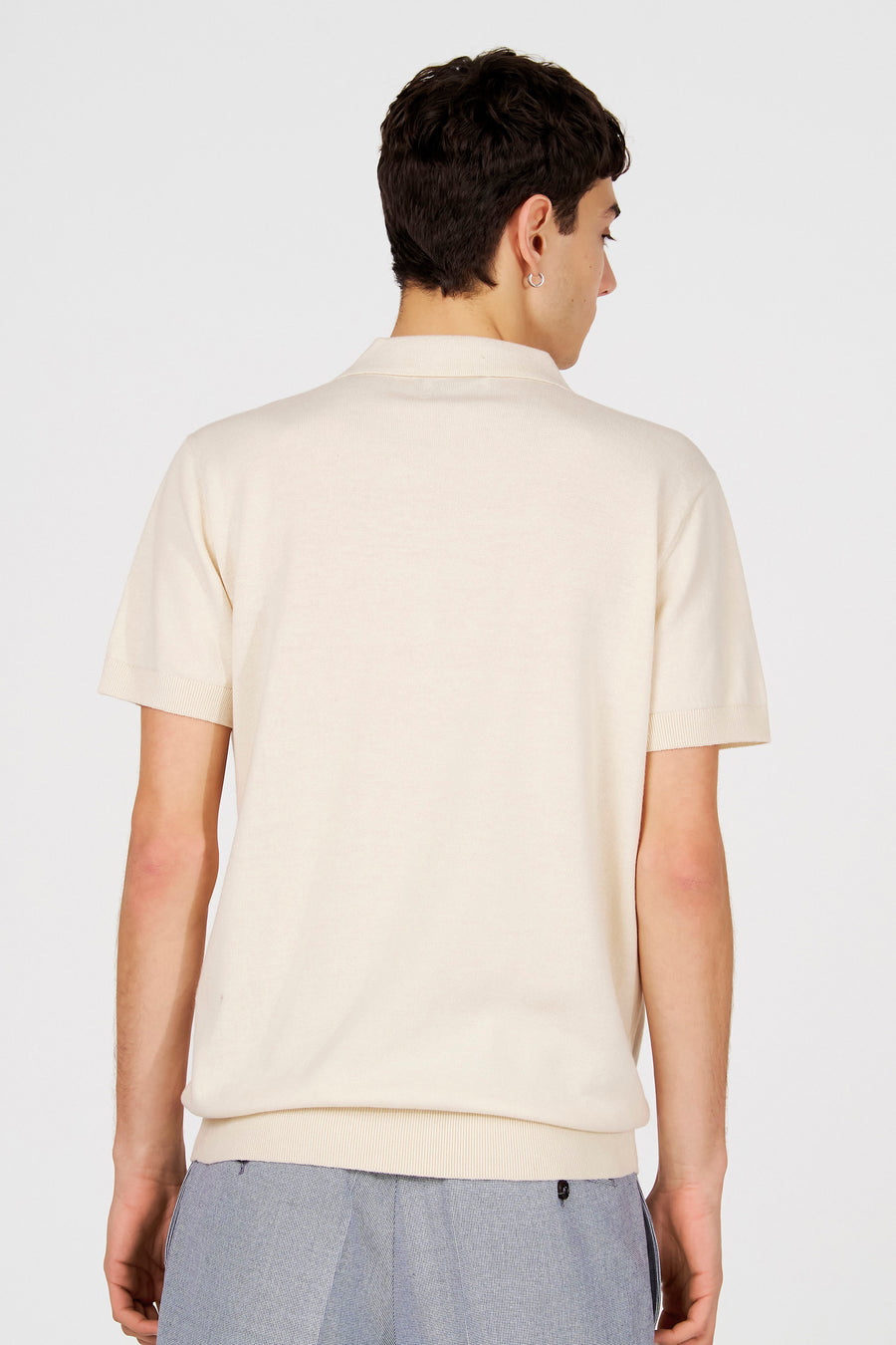 Witte polo van Le Fabuleux Marcel de Bruxelles, gezien van achteren met korte mouwen en ribgebreide details.