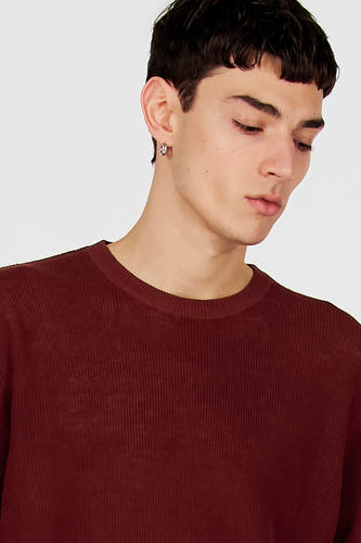 T-shirt marron de Le Fabuleux Marcel de Bruxelles avec de fines côtes, porté par un homme avec une boucle d'oreille argentée.