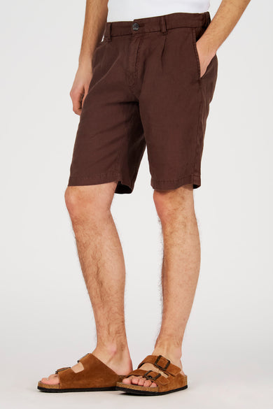 Bermuda marron de Le Fabuleux Marcel de Bruxelles, dos avec poches et boutons, porté avec des sandales en daim.
