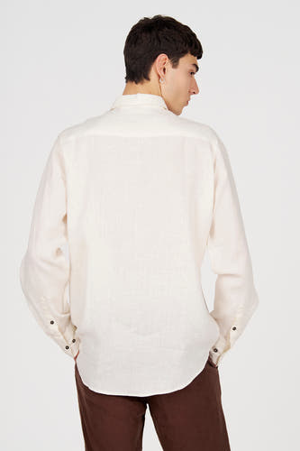 Wit linnen hemd met lange mouwen van Le Fabuleux Marcel de Bruxelles, achteraanzicht met donkere knopen en bruine broek.