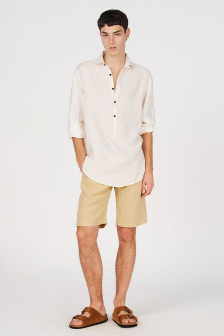 Chemise blanche en lin de Le Fabuleux Marcel de Bruxelles avec demi-patte de boutonnage, manches retroussées et boutons foncés.