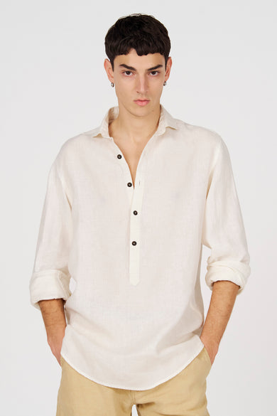 Chemise blanche en lin de Le Fabuleux Marcel de Bruxelles avec une demi-patte de boutonnage et des manches retroussées.