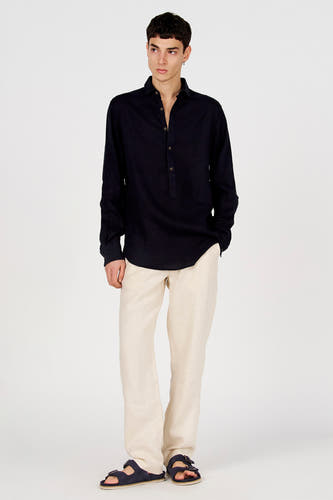Donkerblauw overhemd met lange mouwen van Le Fabuleux Marcel de Bruxelles, met Henley-hals en knopen, gedragen met beige broek en sandalen.