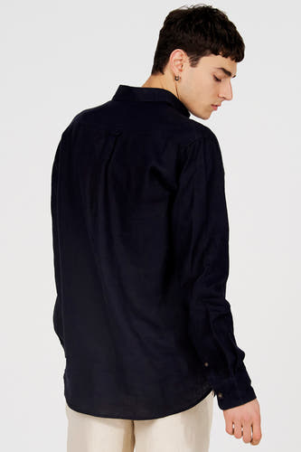 Donkerblauw hemd van Le Fabuleux Marcel de Bruxelles met textuurstof, van achteren gezien op een model met lichte broek.