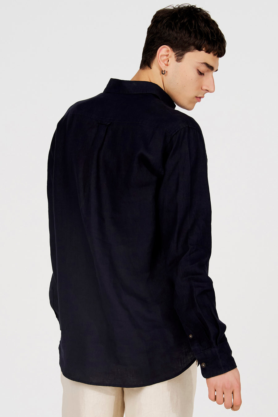 Donkerblauw hemd van Le Fabuleux Marcel de Bruxelles met textuurstof, van achteren gezien op een model met lichte broek.