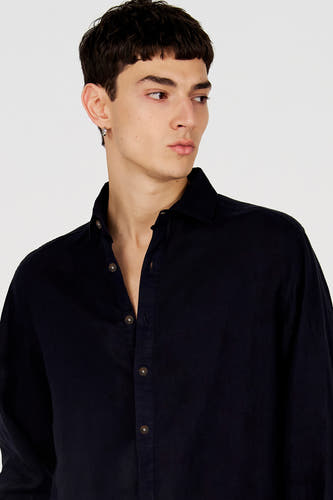 Blauw overhemd van Le Fabuleux Marcel de Bruxelles, met lange mouwen, bruine knopen en openstaande kraag, gedragen door een model.