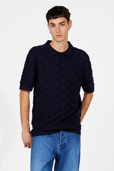 Pull bleu à col en V de Le Fabuleux Marcel de Bruxelles, avec un motif à blocs géométriques au dos.