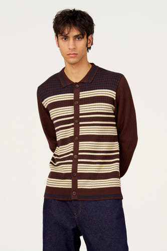 Gilet marron de Le Fabuleux Marcel de Bruxelles avec des rayures horizontales crème et bleu marine, porté avec un jean bleu foncé.