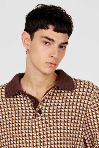 Polo marron de Le Fabuleux Marcel de Bruxelles, avec un motif pied-de-poule et un col marron foncé.