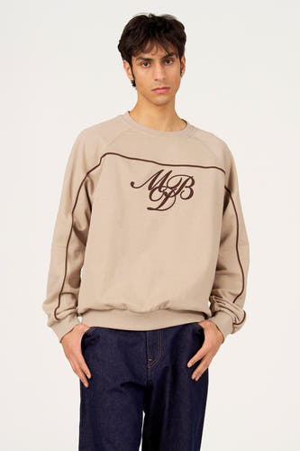 Pull gris à col rond de Le Fabuleux Marcel de Bruxelles, porté par un homme avec un jean foncé vu de dos.