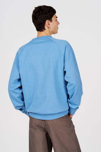 Blauwe sweater met ronde hals van Le Fabuleux Marcel de Bruxelles, gezien van achteren, met bruine pantalon.
