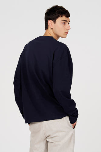 Blauwe sweater met ronde hals van Le Fabuleux Marcel de Bruxelles, gedragen met beige broek, achterkant.
