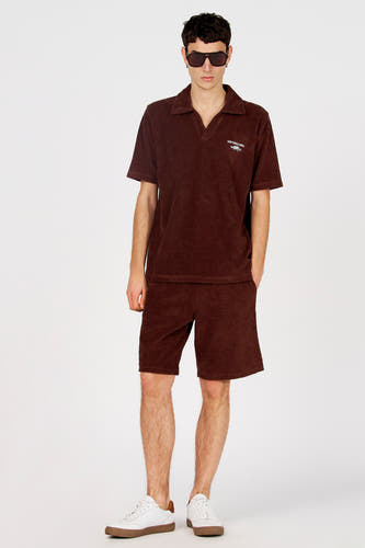 Short marron de Le Fabuleux Marcel de Bruxelles, avec une texture douce, combiné avec un polo marron et des baskets blanches.