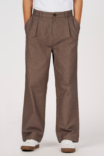 Pantalon marron de couleur de Le Fabuleux Marcel de Bruxelles, avec plis et jambes larges, combiné avec des baskets blanches.