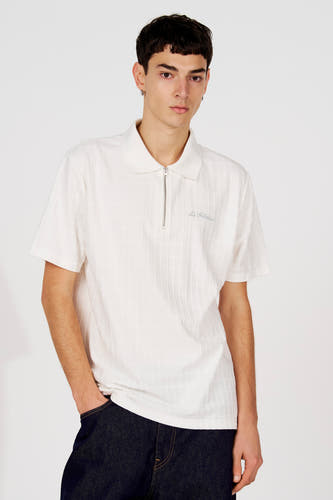 Witte polo van Le Fabuleux Marcel de Bruxelles, met een subtiel blokpatroon en een korte zilverkleurige ritssluiting.
