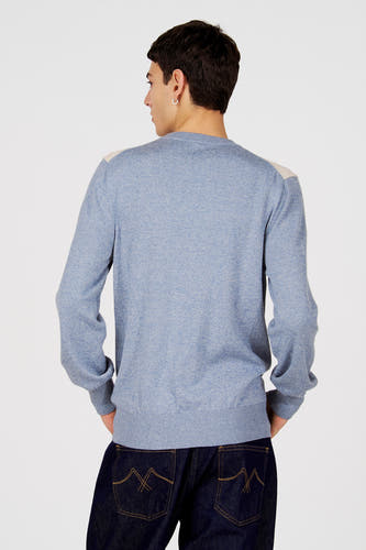 Blauwe trui met ronde hals van Le Fabuleux Marcel de Bruxelles, met roomwitte accenten op de schouders, gecombineerd met donkere jeans.
