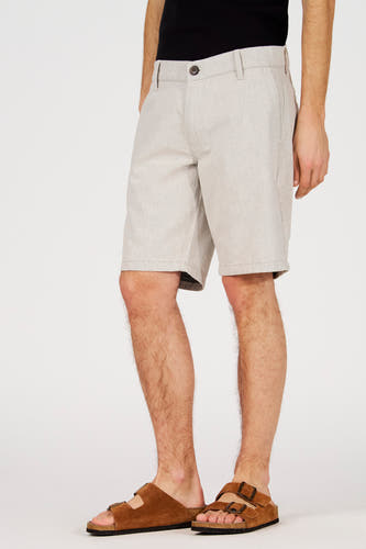 Ecru short van Le Fabuleux Marcel de Bruxelles, met een subtiele textuur en een casual pasvorm, gedragen met bruine sandalen.
