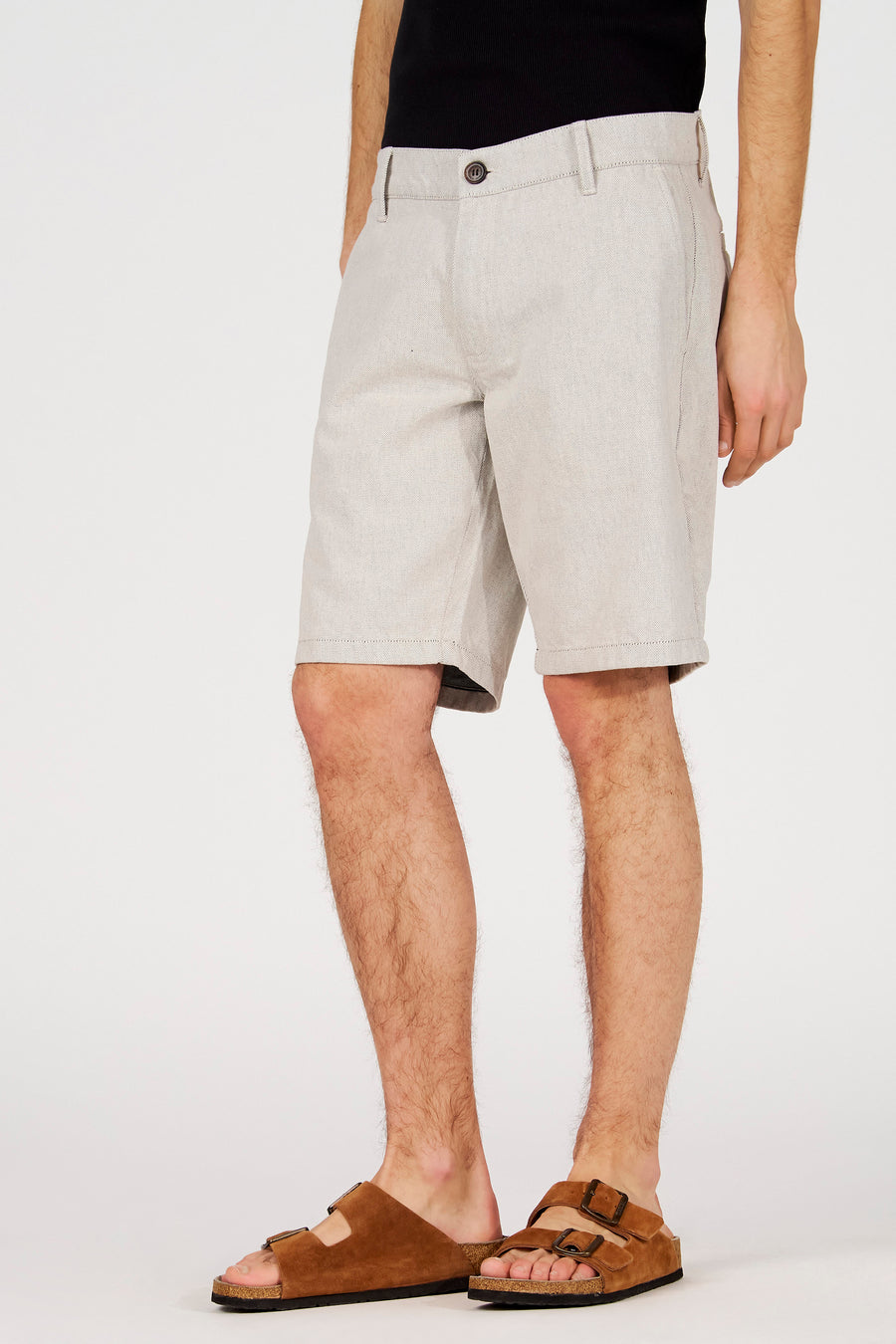 Ecru short van Le Fabuleux Marcel de Bruxelles, met een subtiele textuur en een casual pasvorm, gedragen met bruine sandalen.
