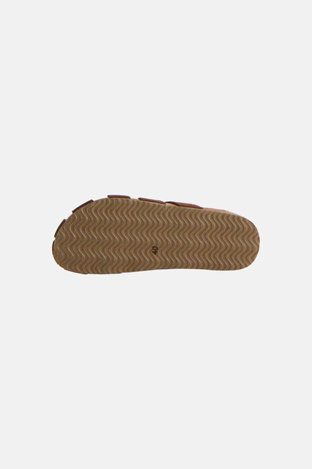Pantoufles marron de Le Fabuleux Marcel de Bruxelles avec un motif ondulé sur la semelle, vues de dessous.