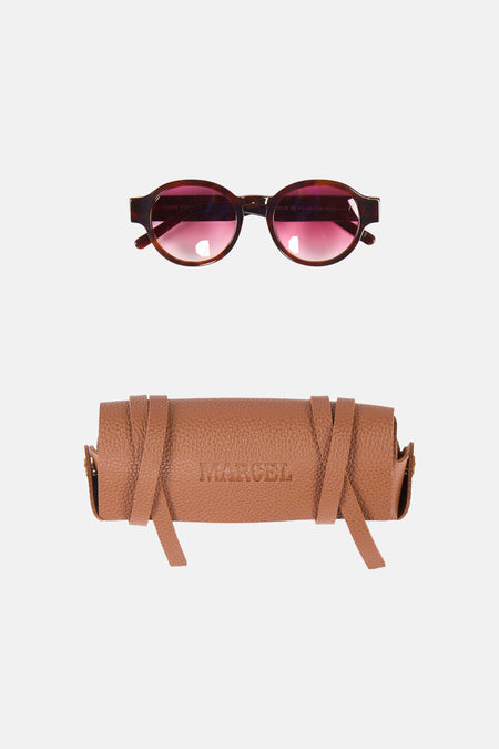 Bruine zonnebril van Le Fabuleux Marcel de Bruxelles, met een bruin leren brillenkoker met 'MARCEL' erop.