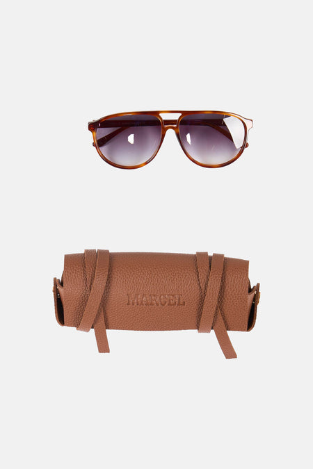 Bruine zonnebril van Le Fabuleux Marcel de Bruxelles met een bruin leren etui met het opschrift "MARCEL".
