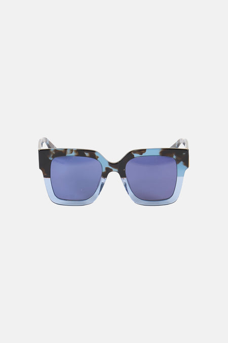 Blauwe zonnebril van Le Fabuleux Marcel de Bruxelles, met een gespikkeld montuur en rechthoekige glazen.
