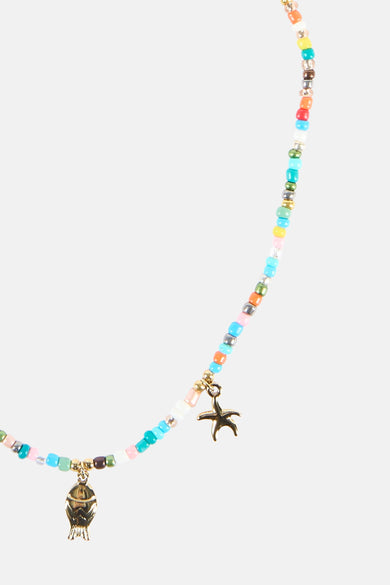 Collier court multicolore de Le Fabuleux Marcel de Bruxelles, avec de petites perles et des breloques dorées en forme de poisson et d'étoile de mer.