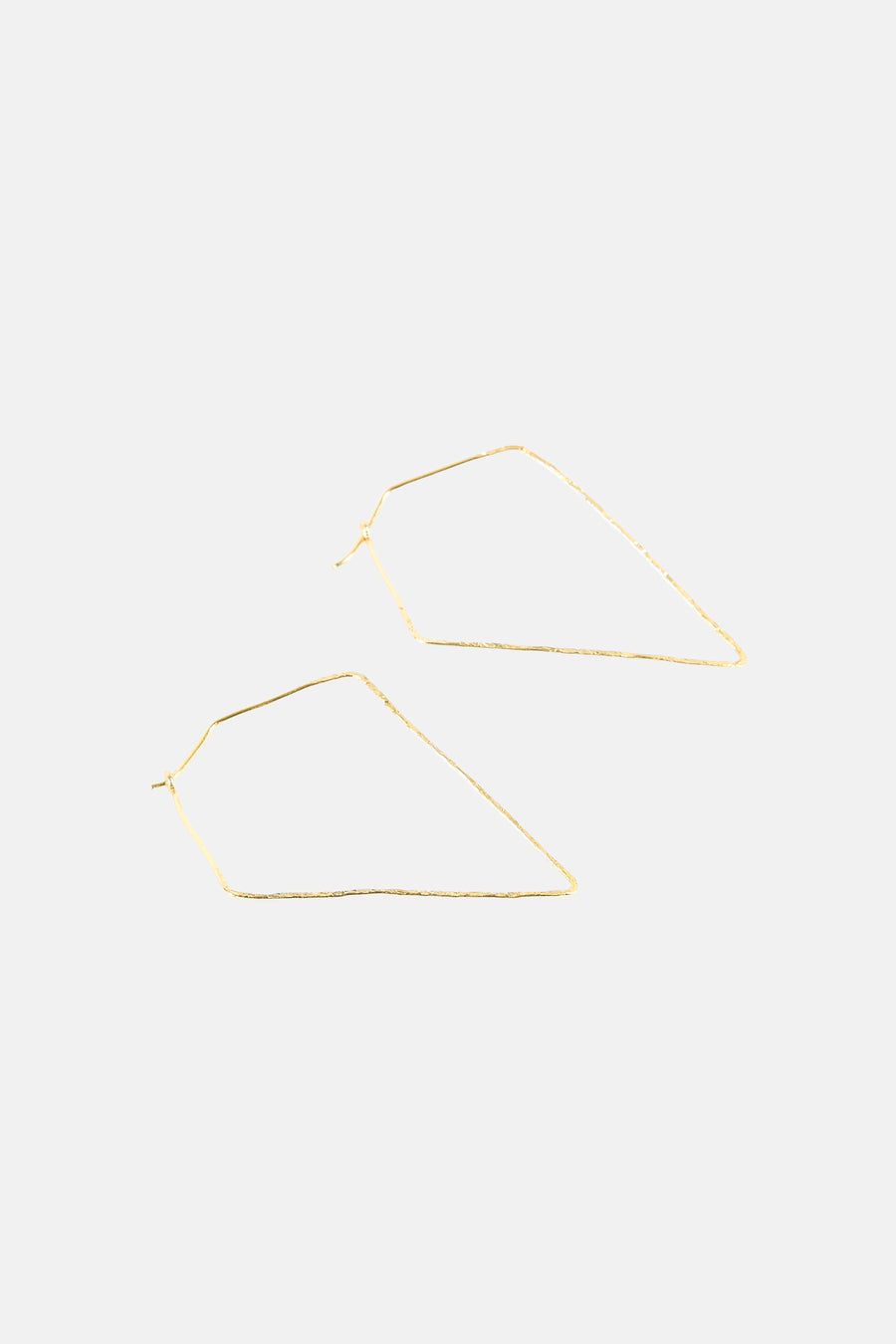 Gouden oorringen van Le Fabuleux Marcel de Bruxelles, met een onregelmatige geometrische vorm en textuur.
