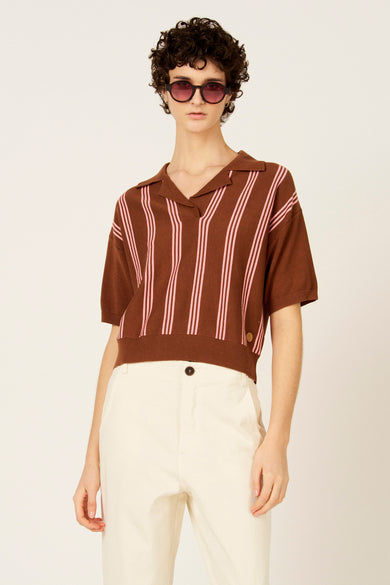 Bruine polo met korte mouwen van Le Fabuleux Marcel de Bruxelles, met roze verticale strepen en witte broek.
