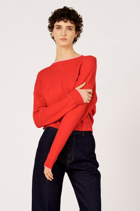 Rode trui met ronde hals van Le Fabuleux Marcel de Bruxelles, gedragen met donkerblauwe jeans.
