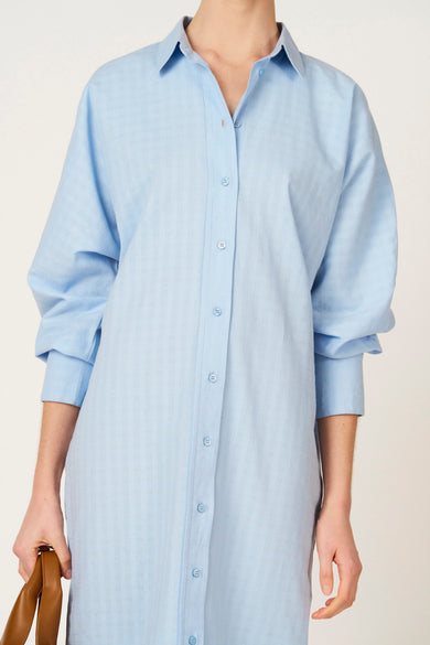 Robe bleue à manches longues de Le Fabuleux Marcel de Bruxelles, avec un motif à carreaux subtil et un col classique.