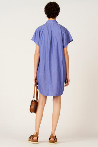 Blauwe jurk met korte mouwen van Le Fabuleux Marcel de Bruxelles, met verticale strepen en een bruine handtas.
