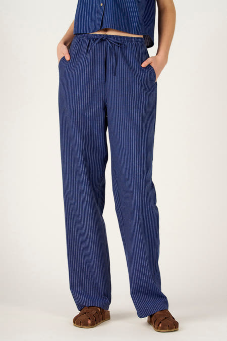 Pantalon bleu de couleur de Le Fabuleux Marcel de Bruxelles avec de fines rayures verticales et un cordon de serrage à la taille.