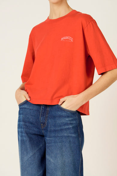 Rood T-shirt met korte mouwen van Le Fabuleux Marcel de Bruxelles, met een logo op de borst en gecombineerd met een blauwe jeans.
