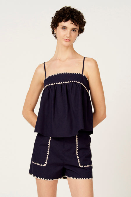 Blauw mouwloze blouse van Le Fabuleux Marcel de Bruxelles, met decoratieve witte randen en een uitlopend model.
