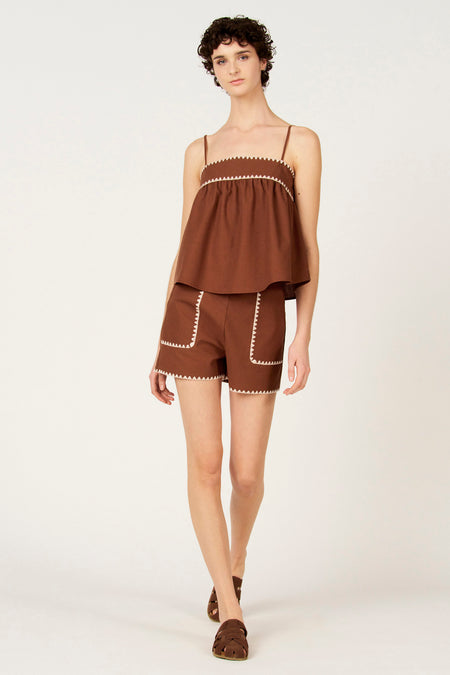 Bruine korte broek van Le Fabuleux Marcel de Bruxelles, met opgestikte zakken afgezet met witte zigzagstiksels.