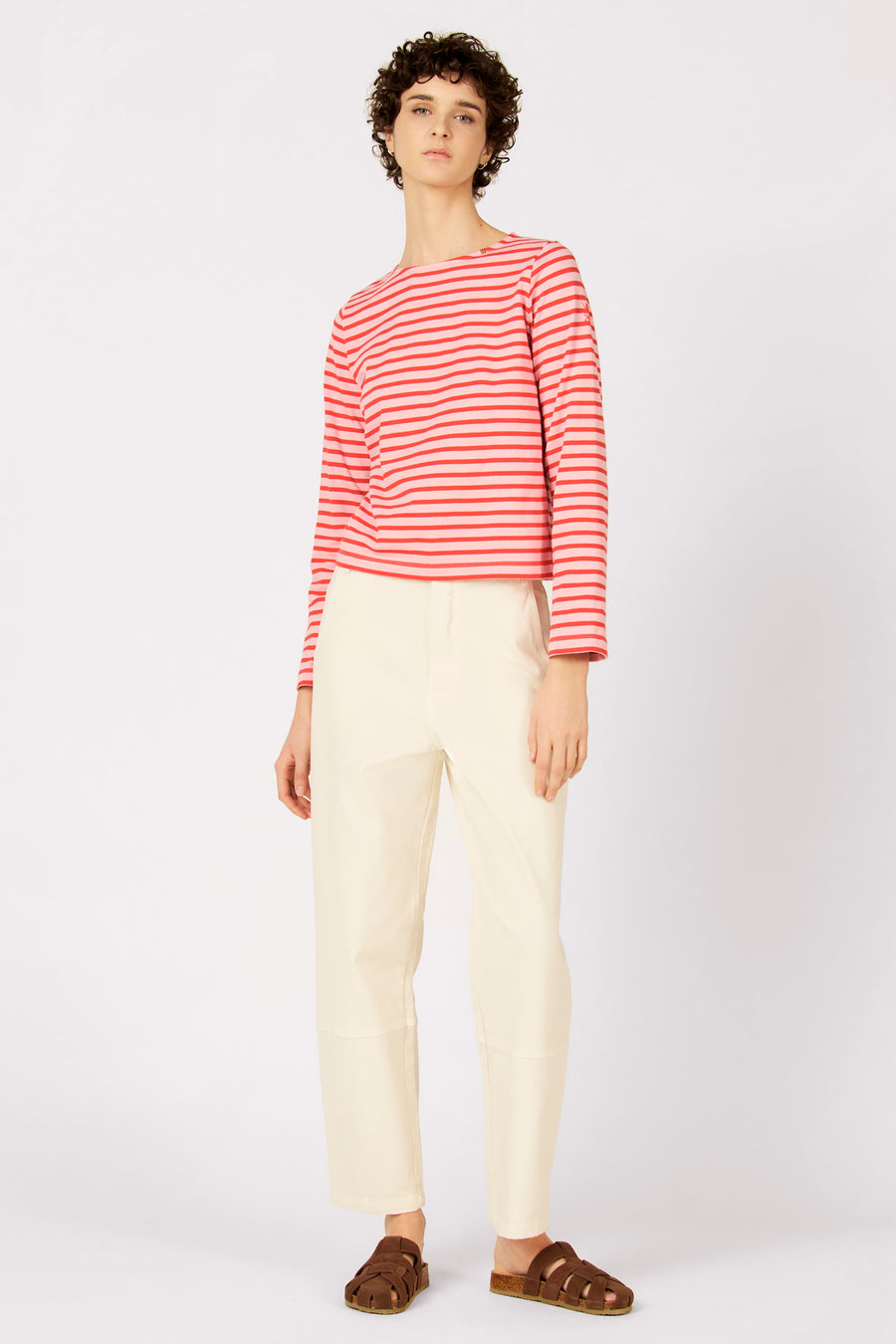Ecru broek van Le Fabuleux Marcel de Bruxelles, gecombineerd met een gestreepte top en bruine sandalen.

