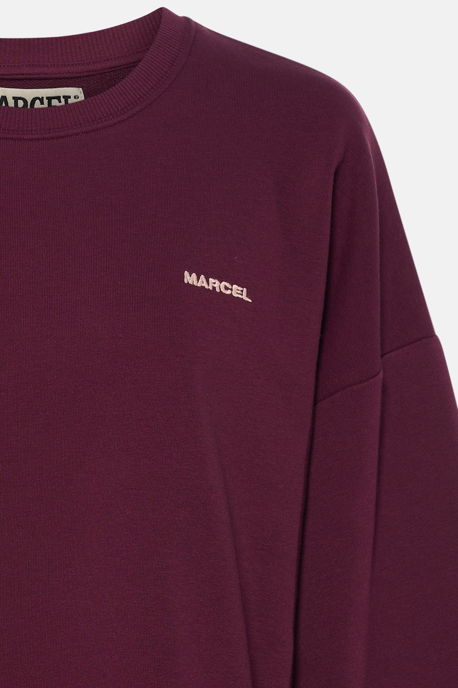 Description détaillée du pull violet à col rond de Le Fabuleux Marcel de Bruxelles, avec 'MARCEL' brodé sur la poitrine.