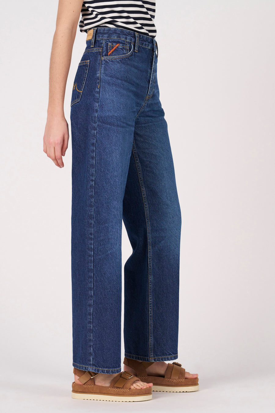 Donker denim jeans wide van Le Fabuleux Marcel de Bruxelles, met hoge taille en bruine sandalen.

