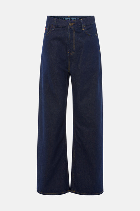 Jean large bleu foncé de Le Fabuleux Marcel de Bruxelles, avec surpiqûres jaunes et jambe droite.