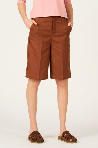 Bruine bermuda van Le Fabuleux Marcel de Bruxelles, met steekzakken en een roze top.