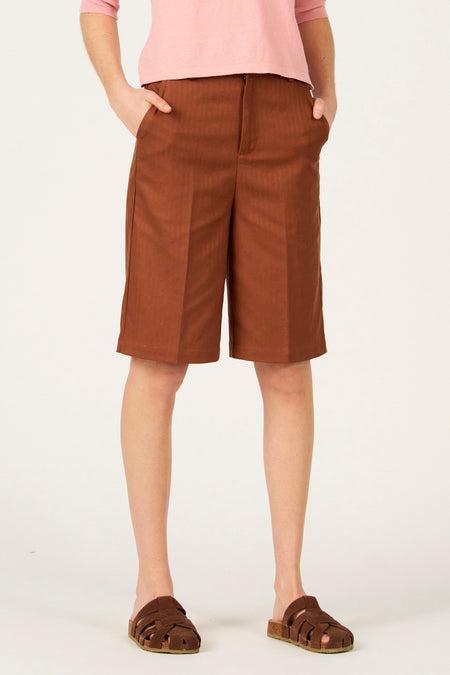 Bruine bermuda van Le Fabuleux Marcel de Bruxelles, met steekzakken en een roze top.