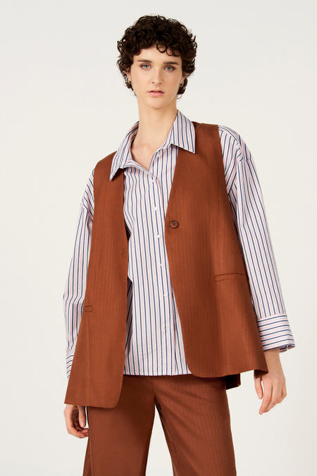 Bruine blazer van Le Fabuleux Marcel de Bruxelles, gedragen over een gestreept overhemd en bijpassende broek.