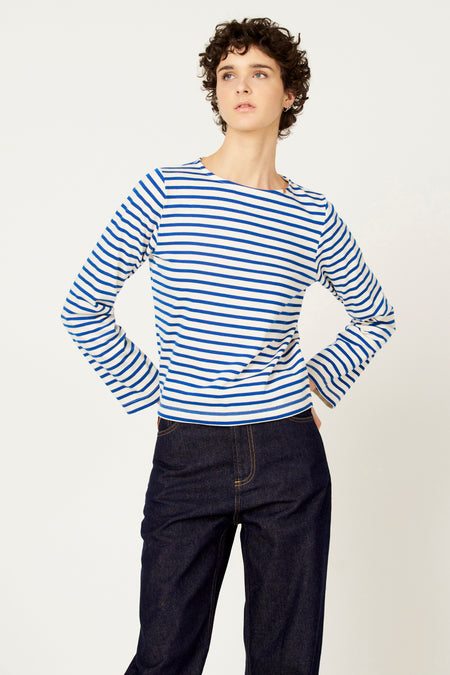 Blauw-wit gestreepte T-shirt met lange mouwen van Le Fabuleux Marcel de Bruxelles, gedragen met donkere jeans.