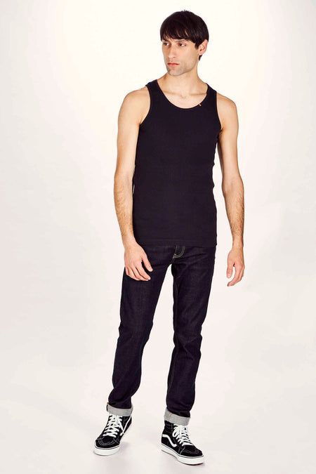 Zwarte tanktop van Le Fabuleux Marcel de Bruxelles, gedragen met donkere jeans en hoge sneakers.